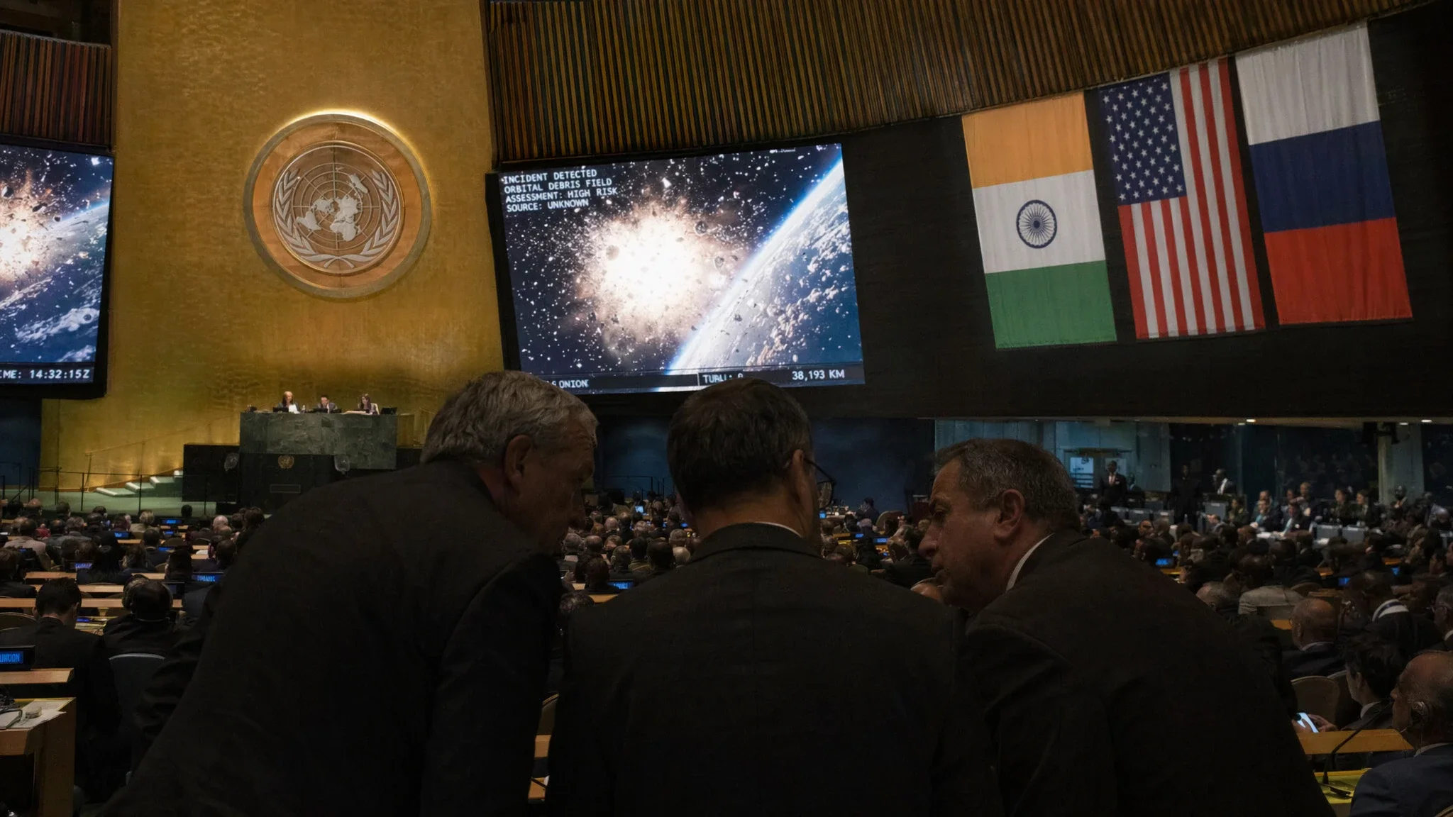 Silhouetted diplomats at UN with satellite explosion images displayed, multinational flags in background. Silhouetted diplomats at UN with satellite explosion images displayed, multinational flags in background.